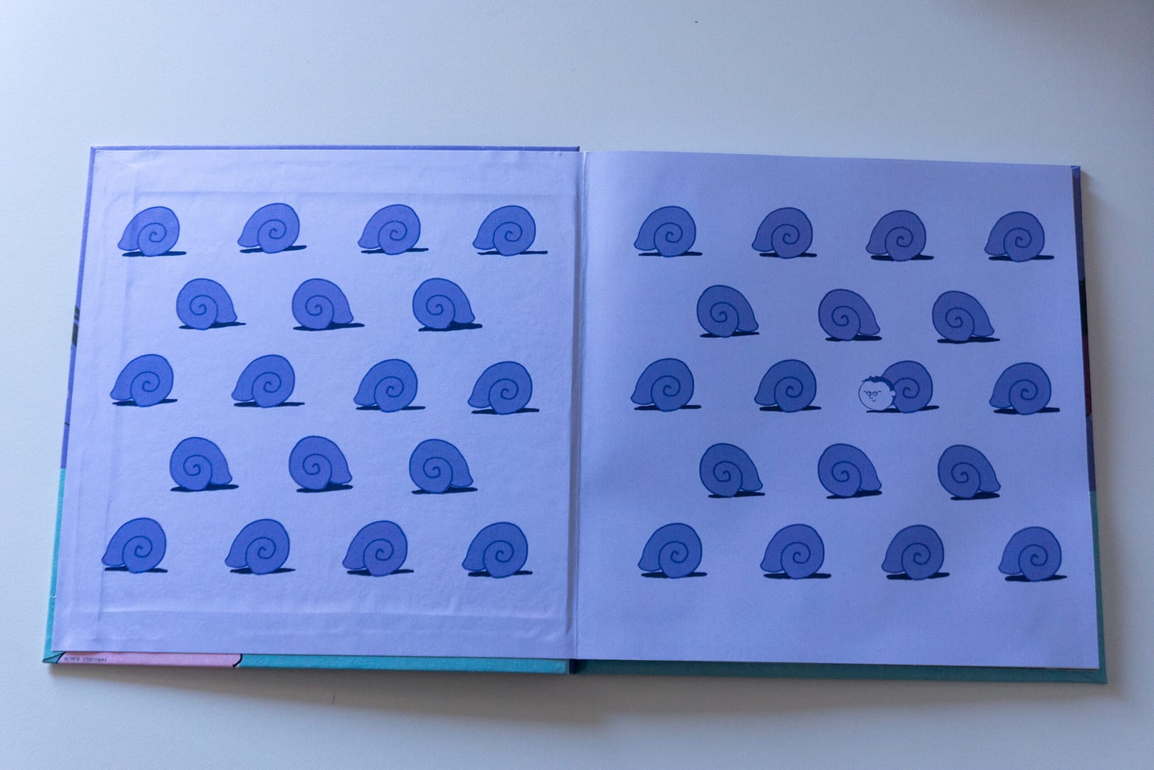 guardas del libro, motivo de caracol repetido. De uno de ellos asoma la cabeza del protagonista, Óscar.