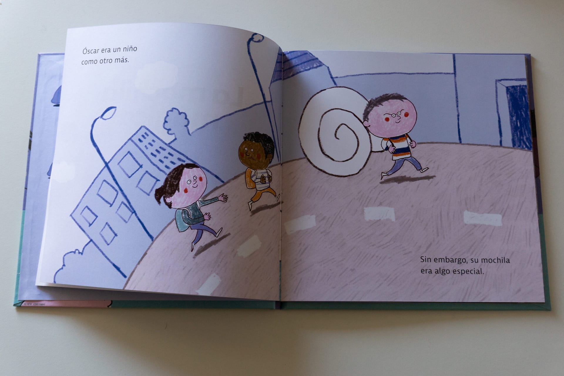 imagen de la primera página del libro. El protagonista Óscar camina con su mochila con forma de caracol